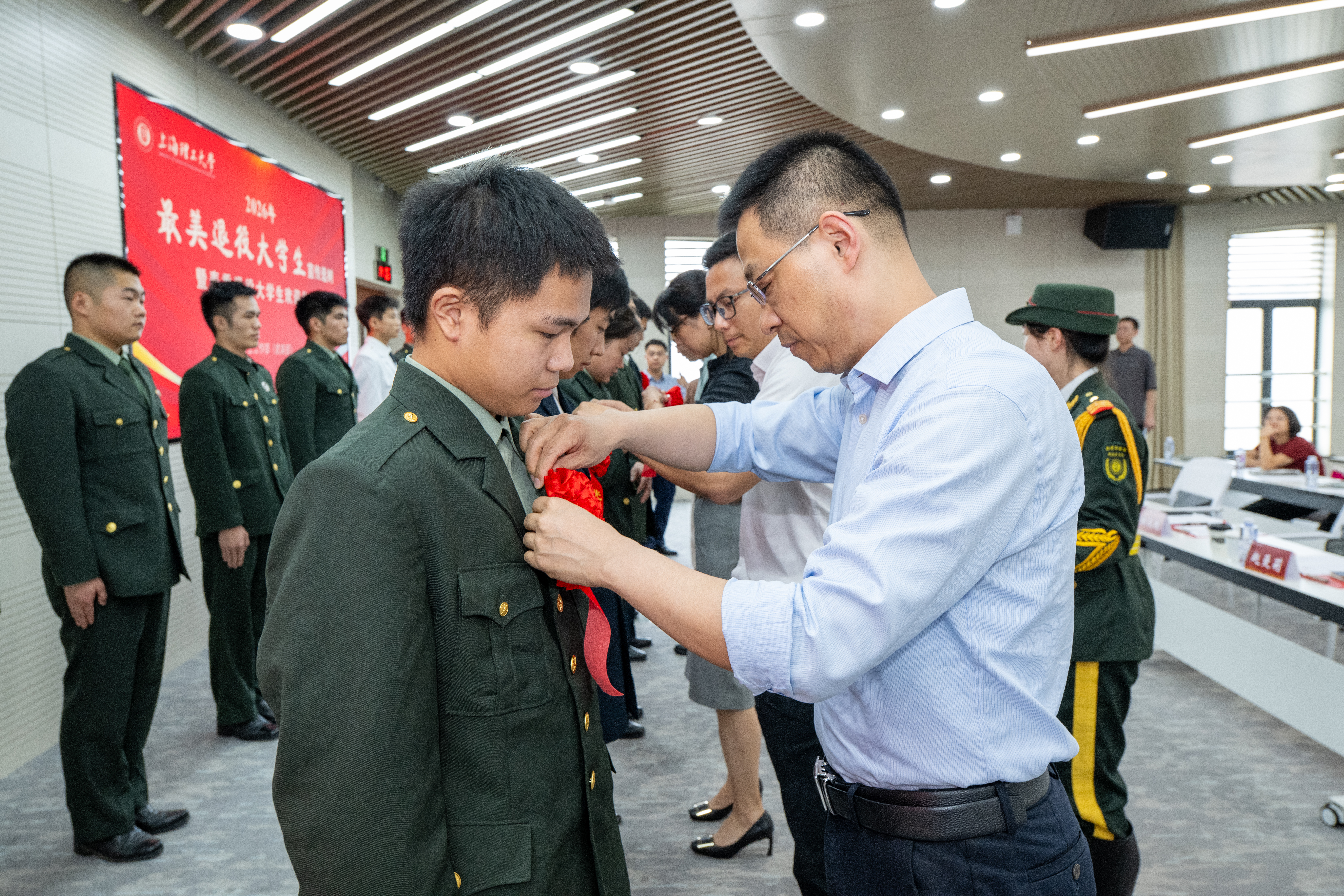 为退役大学生佩戴光荣花